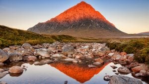 Peak in Scotland turned red by sun reflected in a river