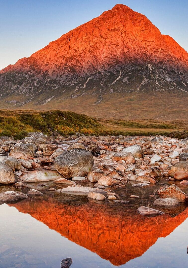 Peak in Scotland turned red by sun reflected in a river